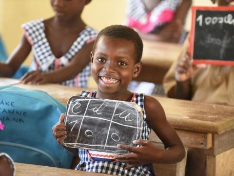 A UNICEF photo showing a happy looking school girl displaying a slate A UNICEF photo showing a happy looking school girl displaying a slate