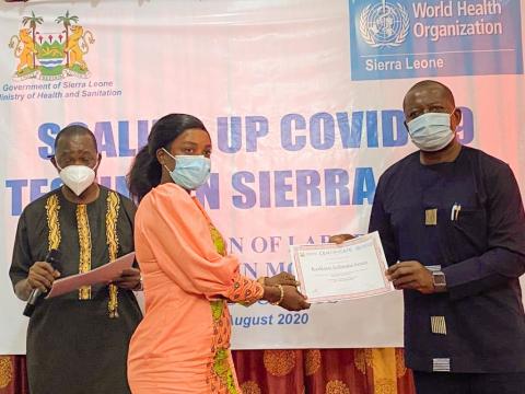 A trainee molecular lab technician receiving a certificate after two weeks intensive training A trainee molecular lab technician receiving a certificate after two weeks intensive training