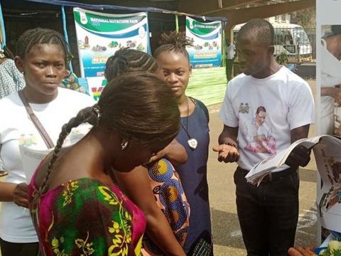 An attendant talks to visitors at the fair An attendant talks to visitors at the fair