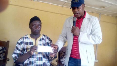 Tom Issic Tucker, MP, handing cheque to Chief Philip Musa Koroma of Nimiyama Chiefdom Tom Issic Tucker, MP, handing cheque to Chief Philip Musa Koroma of Nimiyama Chiefdom