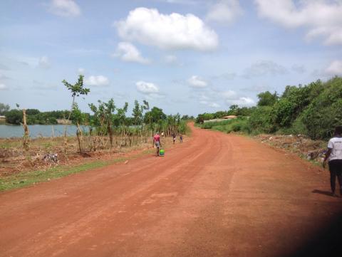 Residents walk along a route beside a mined out pit in Rutile Residents walk along a route beside a mined out pit in Rutile