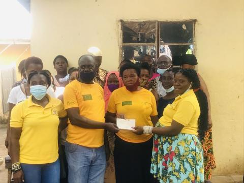 The Project Assistant Coordinator for Rainbow Initiative gives a check of twenty four millions to eight communities in Freetown The Project Assistant Coordinator for Rainbow Initiative gives a check of twenty four millions to eight communities in Freetown