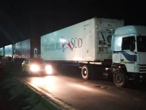 Trucks carrying loaded containers parked along Bia Burreh Road at night. Trucks carrying loaded containers parked along Bia Burreh Road at night.
